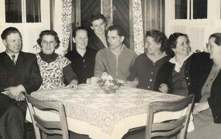 Familienrunde an einem festlich gedeckten Tisch in den 1950er-Jahren.