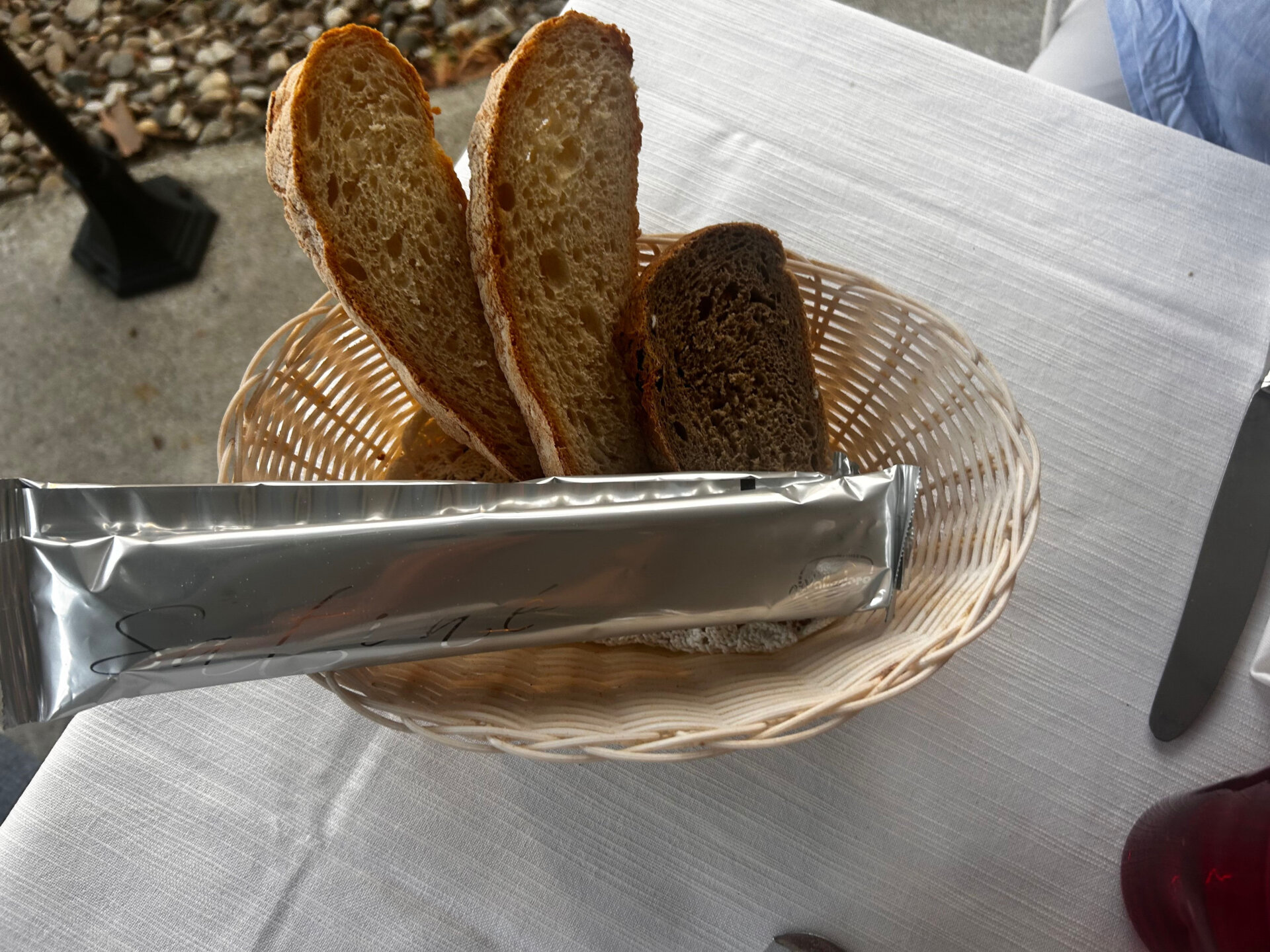 Brotkorb mit verschiedenen Brotsorten auf einem gedeckten Restauranttisch in Italien